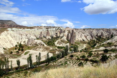 The view on the valley in the mountains with a cart on the foreground.