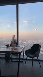 Chairs and table at home against sky