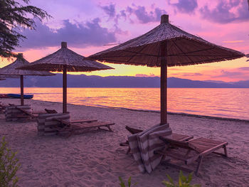 Lifeguard hut on beach against sky during sunset