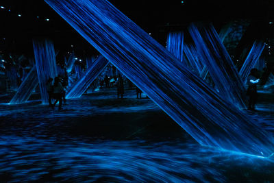 Illuminated bridge over sea at night