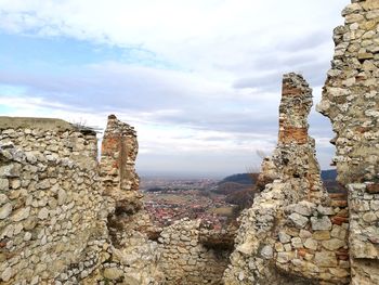 View of ruins of building against cloudy sky