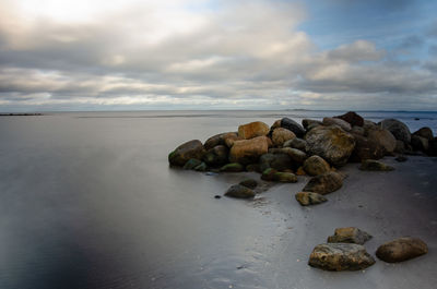 Rocks on beach against sky