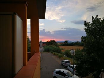 Road amidst trees against sky during sunset