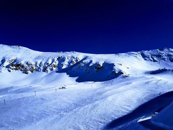 Scenic view of snowcapped mountains against clear blue sky