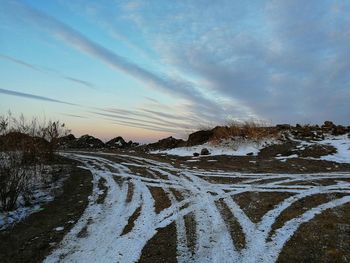 Scenic view of snow covered field against sky