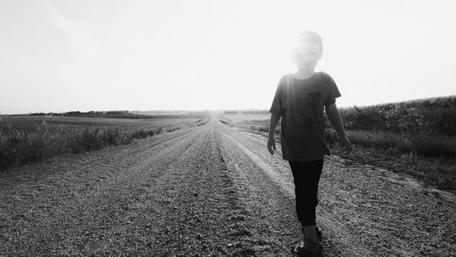 Rear view of man walking on road