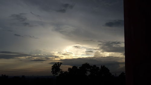 Low angle view of silhouette trees against sky