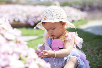 Low angle view of child on pink flowering plant