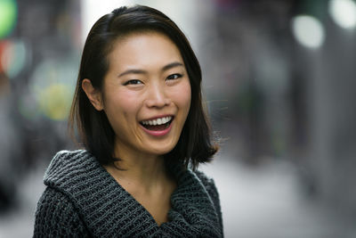 Close-up portrait of cheerful young woman outdoors