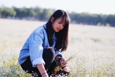 Girl picking flowers on field