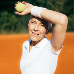 Positive active mature woman having a tennis lesson