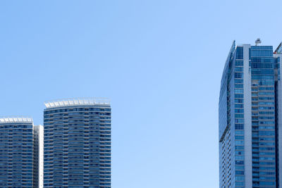 Low angle view of modern buildings against clear blue sky