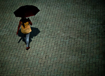 Full length of woman walking on cobblestone