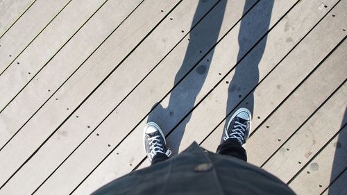 Low section of man standing on hardwood floor