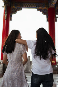 Rear view of women standing in corridor