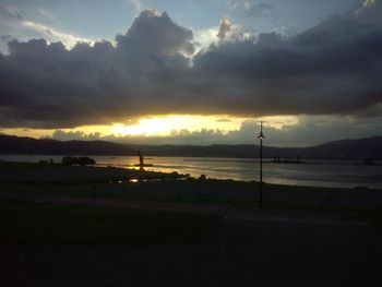 Scenic view of sea against cloudy sky at sunset