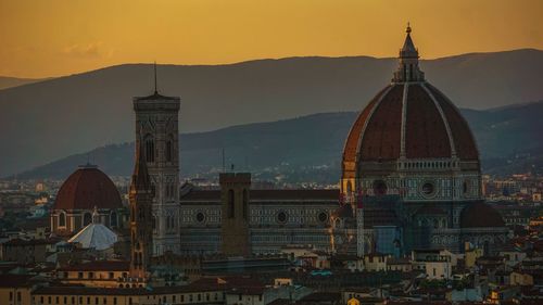 View of buildings in city against sky during sunset