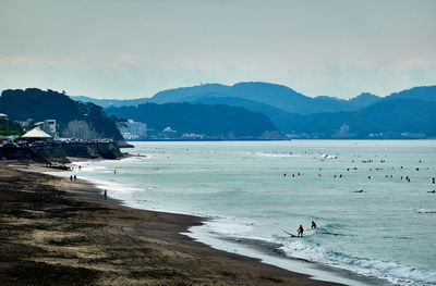 Scenic view of beach and mountains against sky