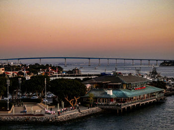 Boats moored at harbor during sunset