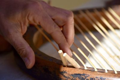 Cropped image of artisan hand touching wooden chair