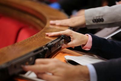 Cropped image of people pressing push buttons on table