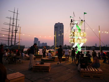 People in city against sky during sunset