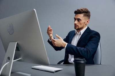 Businessman having video call on desktop pc at desk