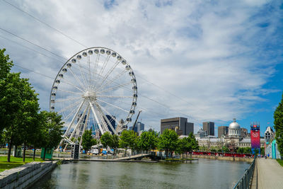 Ferris wheel by trees against sky