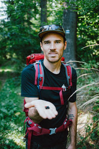 Portrait of man standing against trees in forest