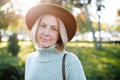 Portrait of young woman wearing hat standing outdoors