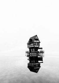 Traditional building by sea against clear sky