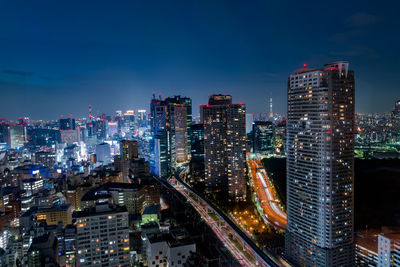 Illuminated cityscape against sky at night