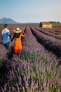 Rear view of couple on field against sky