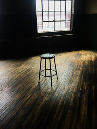 Empty chairs and table against window