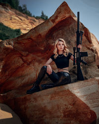 Portrait of woman sitting on rock