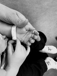 Cropped hands of parent sitting with baby