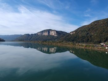 Scenic view of lake by mountains against sky