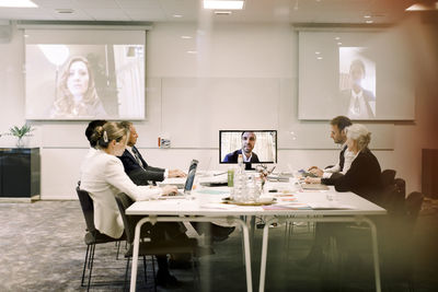 Business executives discussing during global conference meeting in board room at office