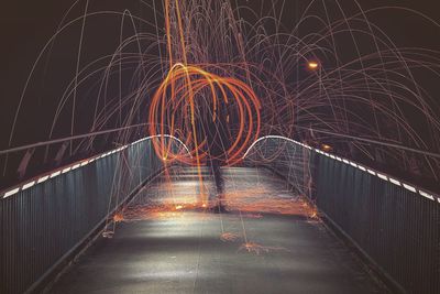 Light trails on road against sky at night