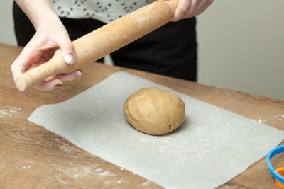 Midsection of woman preparing dough on table