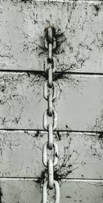 Close-up of chain on wooden wall