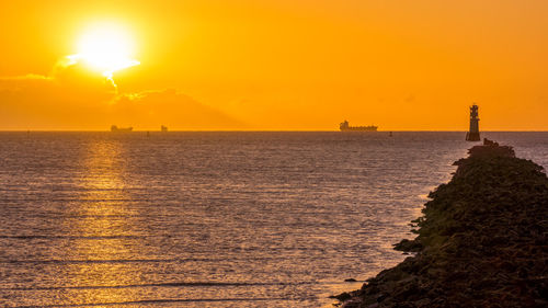 Scenic view of sea against orange sky