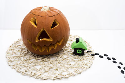 Close-up of pumpkin on table against white background