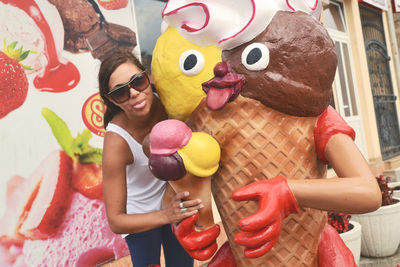 Young woman standing by ice cream statue