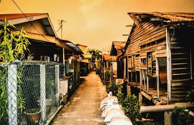 Rear view of people on footpath amidst buildings against sky