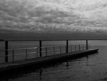 Pier over sea against cloudy sky