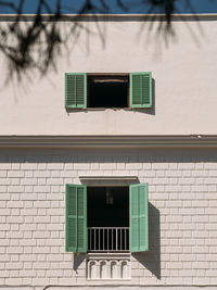 Wooden light green shutters on the window of a typical white house on the island of ibiza, spain.