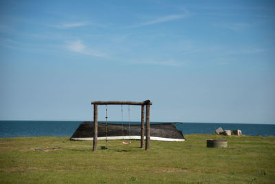 Play equipment at beach against sky