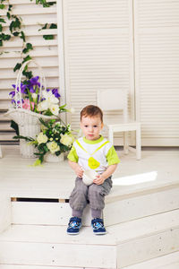 Portrait of cute boy sitting on floor