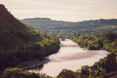 Scenic view of river against cloudy sky